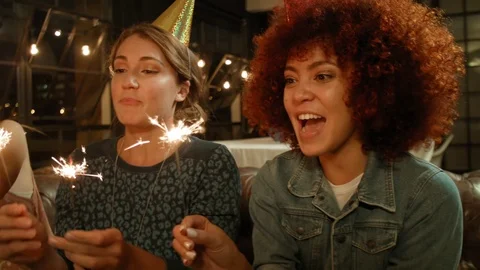 Close up on womens' faces smiling with sparklers Stock Footage 76999912