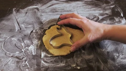 Close-up of women's hands carving rabbit-shaped biscuits out of the dough. The Video stock 174698452