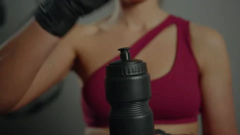 Close-up of women's hands closing a bottle of water at a workout in the gym Stock Footage 178923102