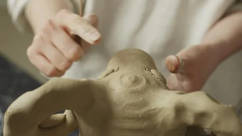 Close-up of women's hands decorating and shaping a ceramic product made of clay Stock Footage 241232203
