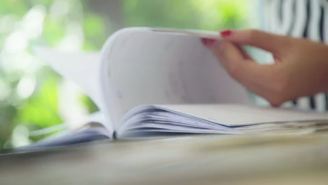 Close-up: women's hands flipping through a diary with a bookmark Stock-Footage 94378846