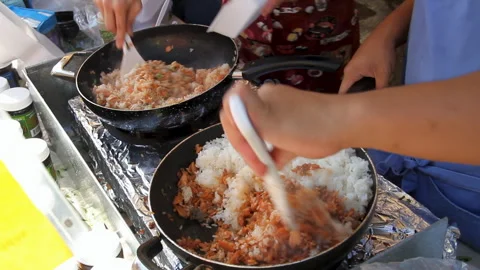 Close-up -women's hands making fried rice at an outdoor farmers market. Stock Footage 272345630