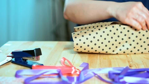 Close-up of women's hands packing a gift. 스톡 동영상 105945567