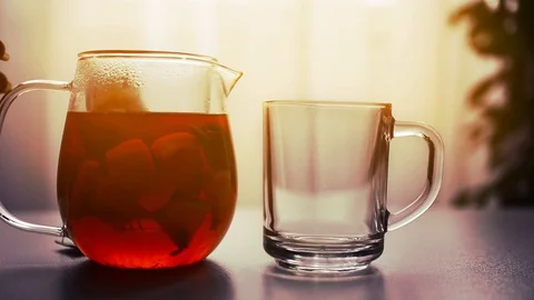 Close-up of women's hands pouring tea into a Cup in the early morning Stock Footage 128442561