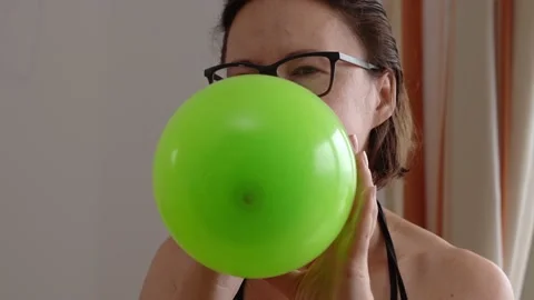 Close-up of women's hands quickly pick up colored balloons to inflate them for Stock Footage 201607313