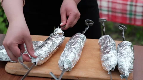 Close-up of women's hands that remove the foil from the shish kebab Stock Footage 194543231