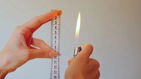 Close-up of women's hands setting fire to a lighter and measuring with a Stock Footage 202205883