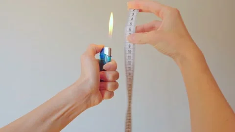 Close-up of women's hands setting fire to a lighter and measuring with a Stock Footage 202319017