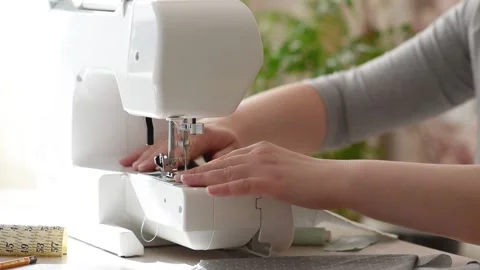 Close-up of women's hands sewing on a sewing machine Stock Footage 184429852