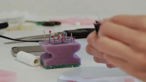 Close-up of women's hands threading a white thread into the little eye of a Stock Footage 201676310