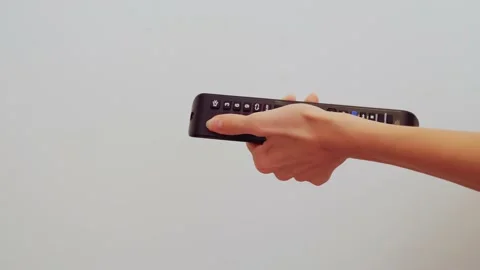 Close-up women's hands try to turn on the TV, but they can't do it and they hit Stock Footage 202319336