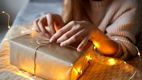Close-up of women's hands that untie the string on a new year's gift Stock Footage 135690603