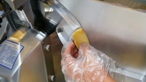 Close-up of women's hands use professional electric food slicer, slices cheese Stock Footage 111965129