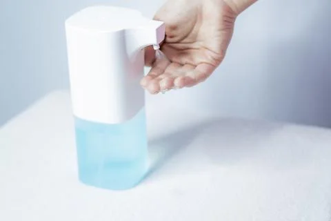Close-up of women's hands using an automatic sanitizer dispenser Stock Photos