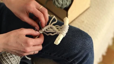 Close up of women's hands weaving macrame in a home workshop. Stock Footage 154342562
