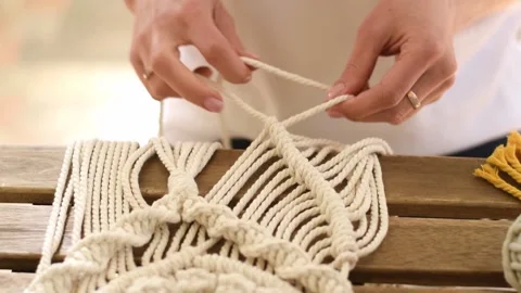 Close up of women's hands weaving macrame in a home workshop. Stock Footage 154343350