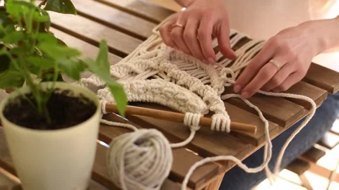 Close up of women's hands weaving macrame in a home workshop. Stock Footage 154343523