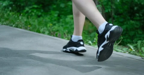 Close up of womens legs running on asphalt road Stock Footage 155106913