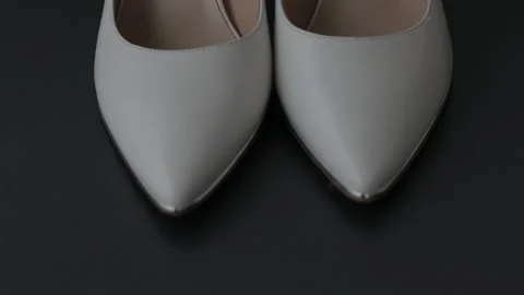 Close-up of womens light-colored high heels on a table in slow motion Stock Footage 321475118