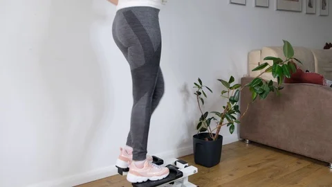 Close up womn legs working out on the stepper exercise machine at home, stepper Stock Footage 128350764