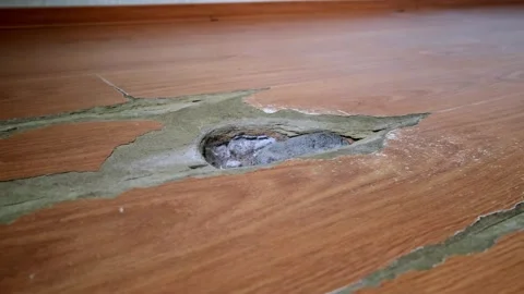 Close-up of a wood laminate surface with visible signs of wear and a large .. Stockbeeldmateriaal 314979259