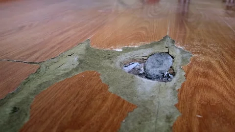 Close-up of a wood laminate surface with visible signs of wear and a large .. Video stock 315093106