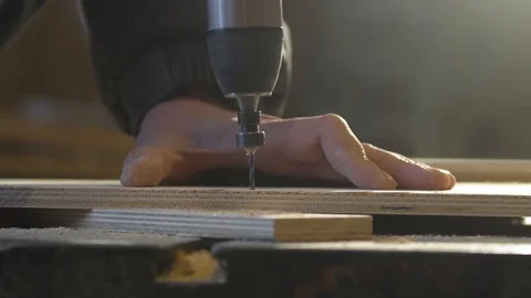 Close up of Wood Worker using an electric hand drill to drill a hole through the Бесплатное стоковое видео 107613264