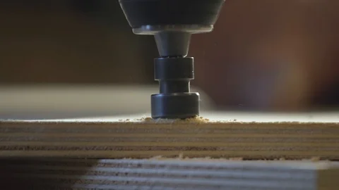 Close up of Wood Worker using an electric hand drill to drill a hole through the Stock-Footage 107613314
