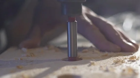 Close up of Wood Worker using an electric hand drill to drill a hole through the Stock-Footage 107613439
