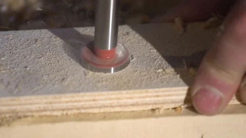 Close up of Wood Worker using an electric hand drill to drill a hole through the Stock Footage 107613570