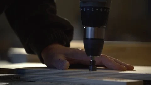 Close up of Wood Worker using an electric hand drill to drill a hole through the Stock Footage 107613675