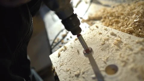 Close up of Wood Worker using an electric hand drill to drill a hole through the Stock-Footage 107613754