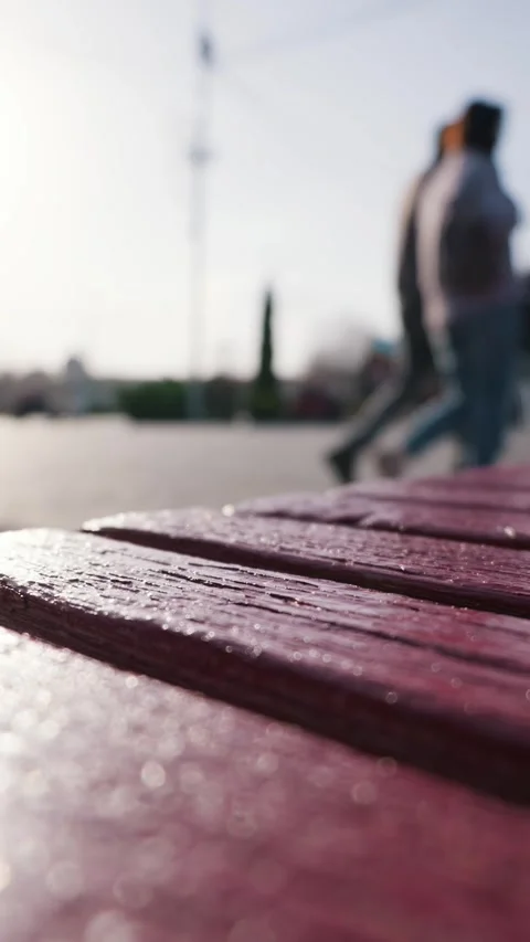 Close Up of Wooden Bench Slats While Blurred People Walk in a Public Space Видео 334105505