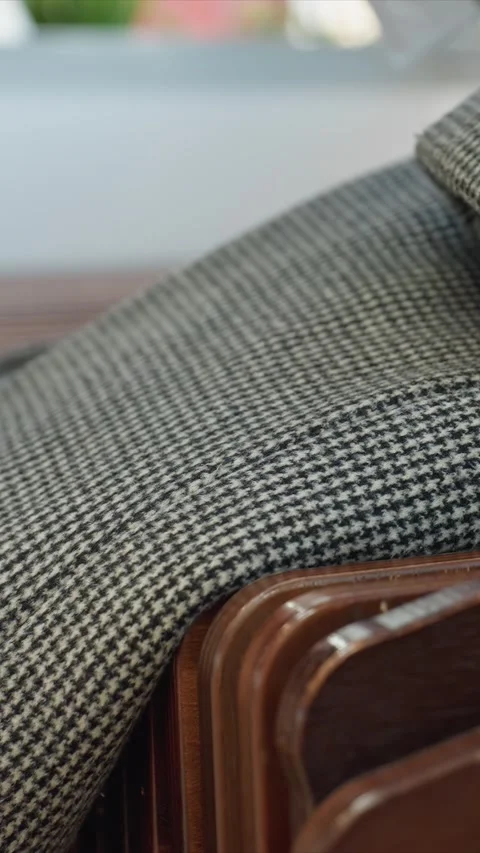 Close up of wooden chairs with parallel slats and black white houndstooth fabric Stock Footage 344668784