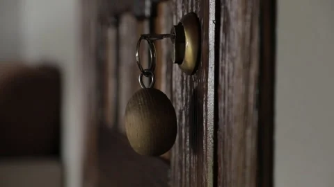 A close-up of wooden doors with a key inserted, featuring a wooden keychain Stock Footage 322060919