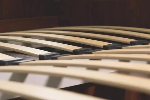 Close-up wooden elements of an arthopedic base of a double bed. Interior 스톡 사진