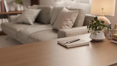 Close up of wooden table with notebook and potted plant beside grey sofa in.. 스톡 일러스트
