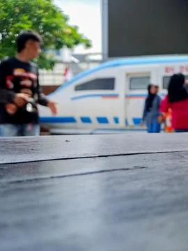 Close up of wooden table surface with blurred people and train in the backg.. Stock Photos