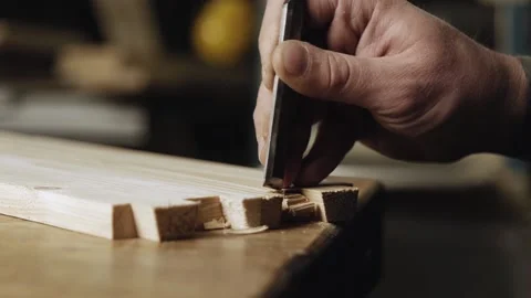Close up. a woodworker cuts out a dovetail on a pine board with a chisel. Stock Footage 166341019