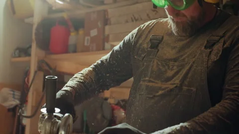 Close up Woodworker Operates Angle Grinder in Workshop showing joiner carpenter Stock Footage 348120821