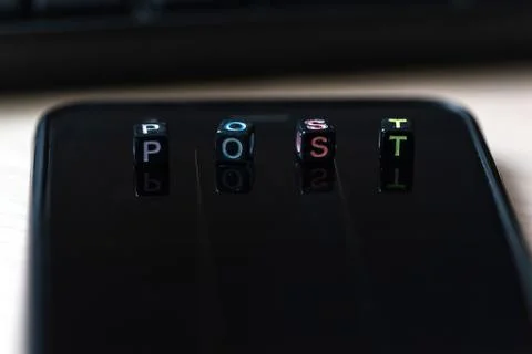 Close up words POST on blocks on black smart phone on desk Stock Photos