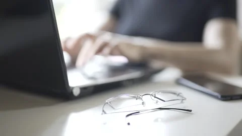 Close-up of work of hands at the computer, glasses are in the foreground Stock Footage 241088740