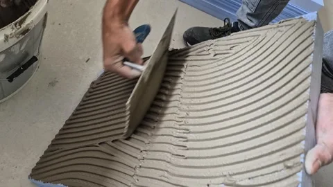 Close Up of Worker Applying Cement Adhesive onto XPS Foam Board Stock Footage 340643643