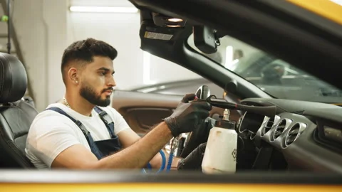 Close up of worker of auto service station, cleaning modern vehicle interior Stock Footage 233592209