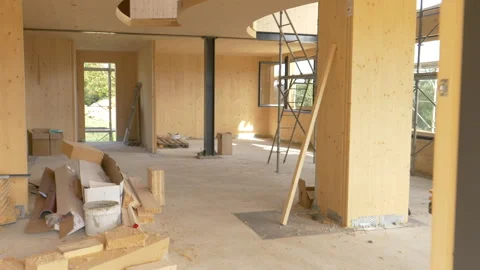 CLOSE UP: Worker carries a log across the first floor of a prefabricated house. Stock Footage 135360752