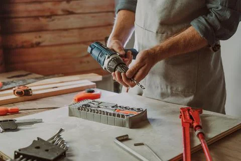 Close up of worker changing a drill for screwdriver Stock Photos