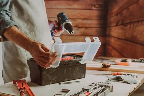 Close up of worker changing a drill for screwdriver Stock Photos