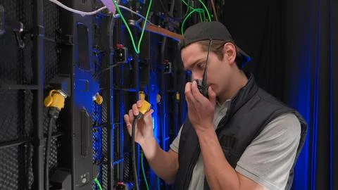 Close up worker checking big led screen panels wires. Technician service Stock Photos