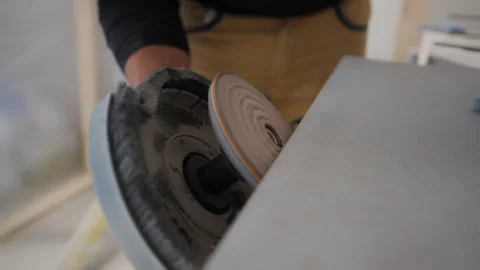 Close-up of worker in construction uniform using an electric sanding tool to Stock Footage 327024651