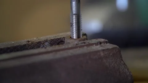 Close up worker cuts the damaged thread of a nut bolt clamped in a vise. Steel Vídeos de archivo 231251486